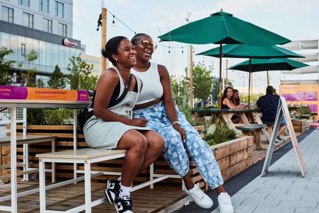 Deux femmes qui posent et sourient là la Station Culturelle Momo près de la Place Bell à Laval